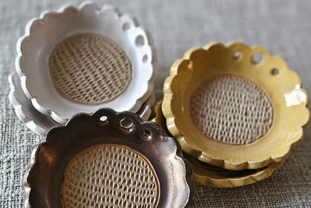 Handcrafted scalloped ceramic mini dishes stacked on fabric by Whistle and Page